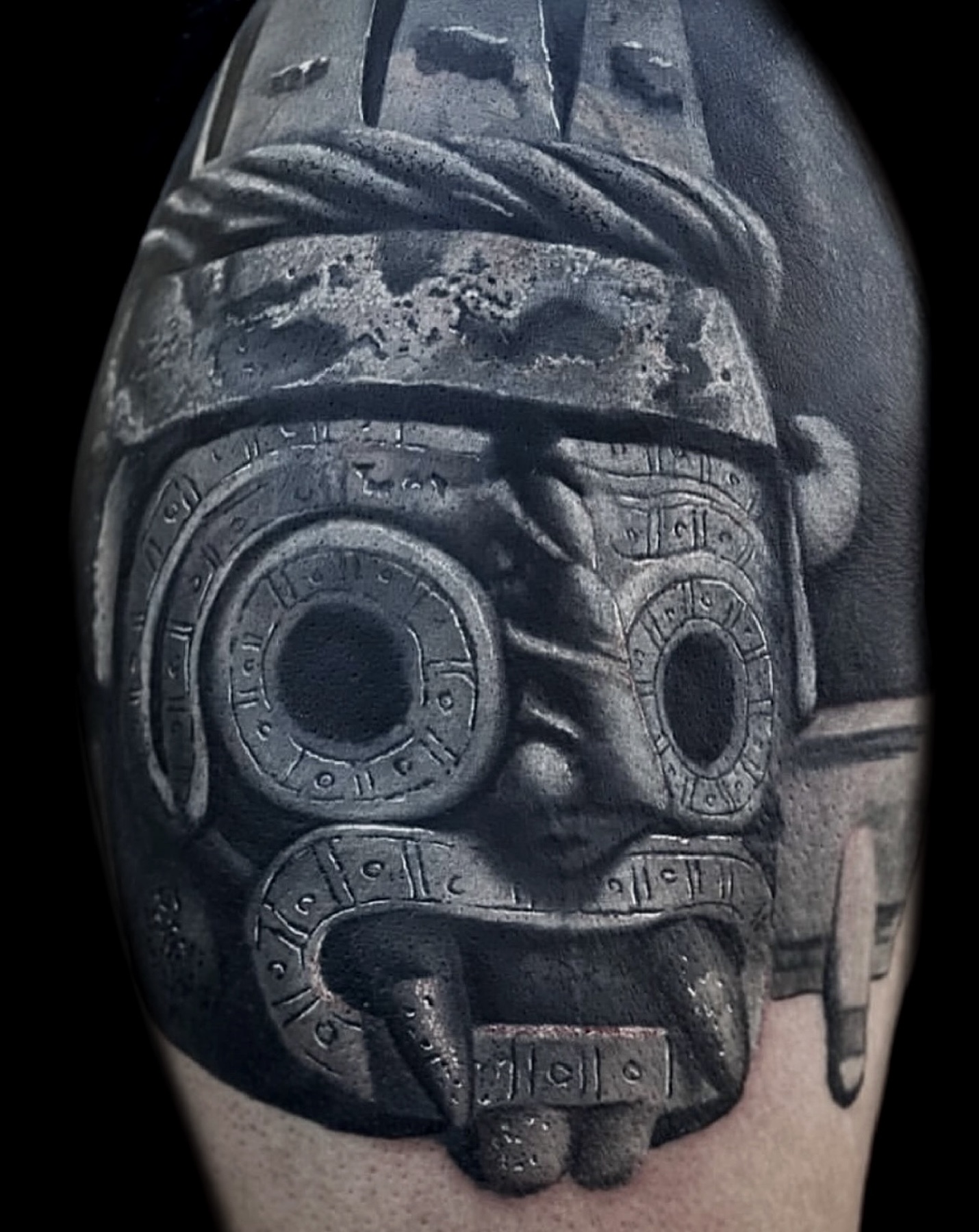Black and grey Aztec-inspired skull tattoo